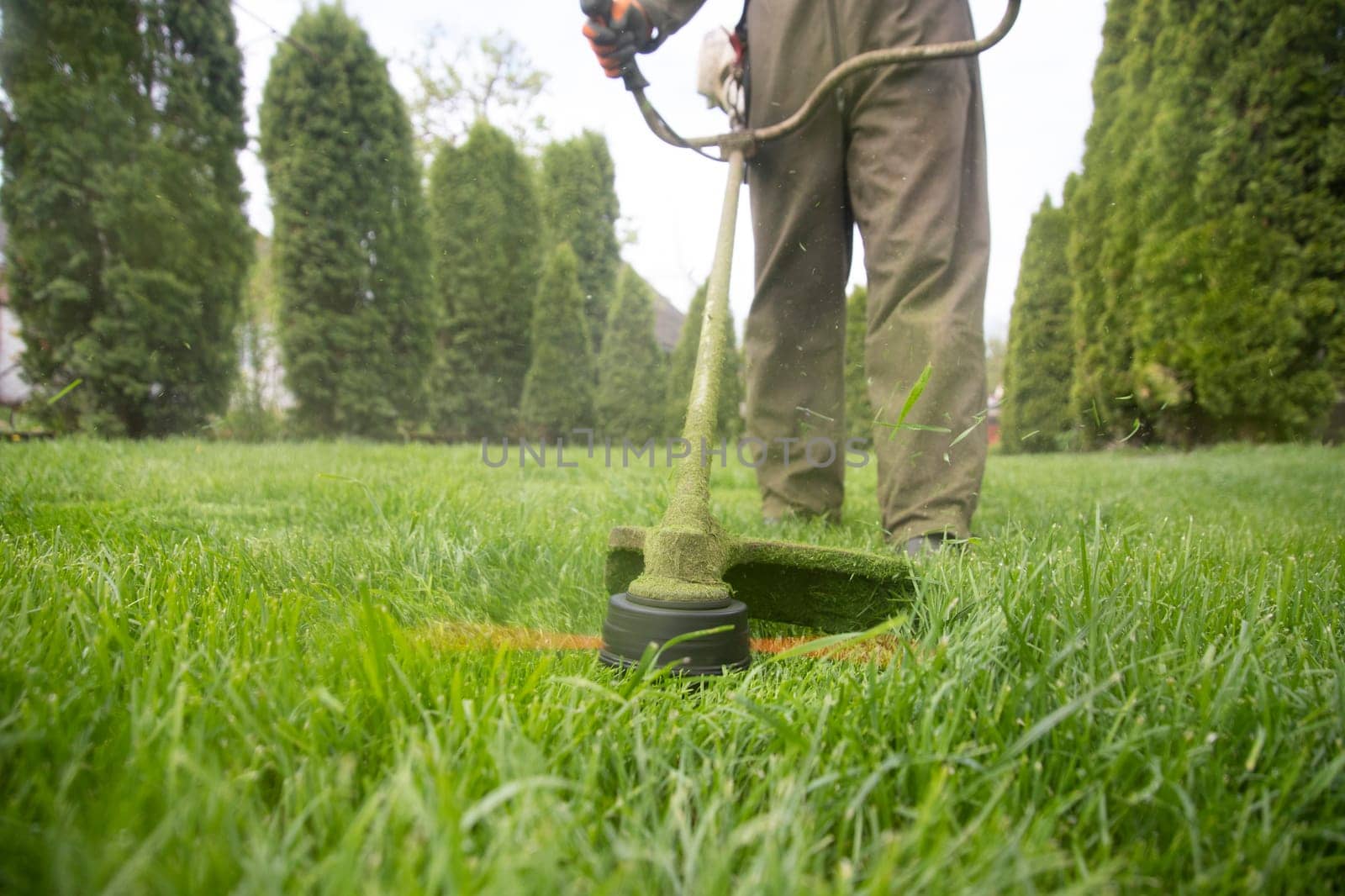 Mowing the grass with a lawn mower. Garden work concept background.