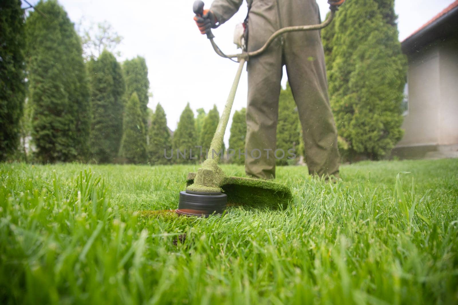 Mowing the grass with a lawn mower. Garden work concept background.
