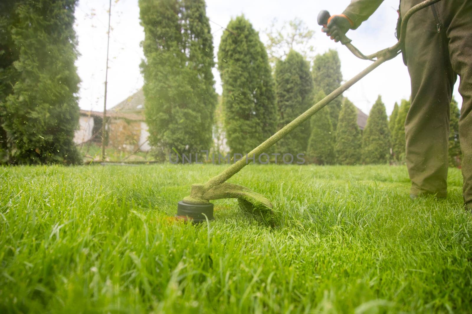 Mowing the grass with a lawn mower. Garden work concept background.