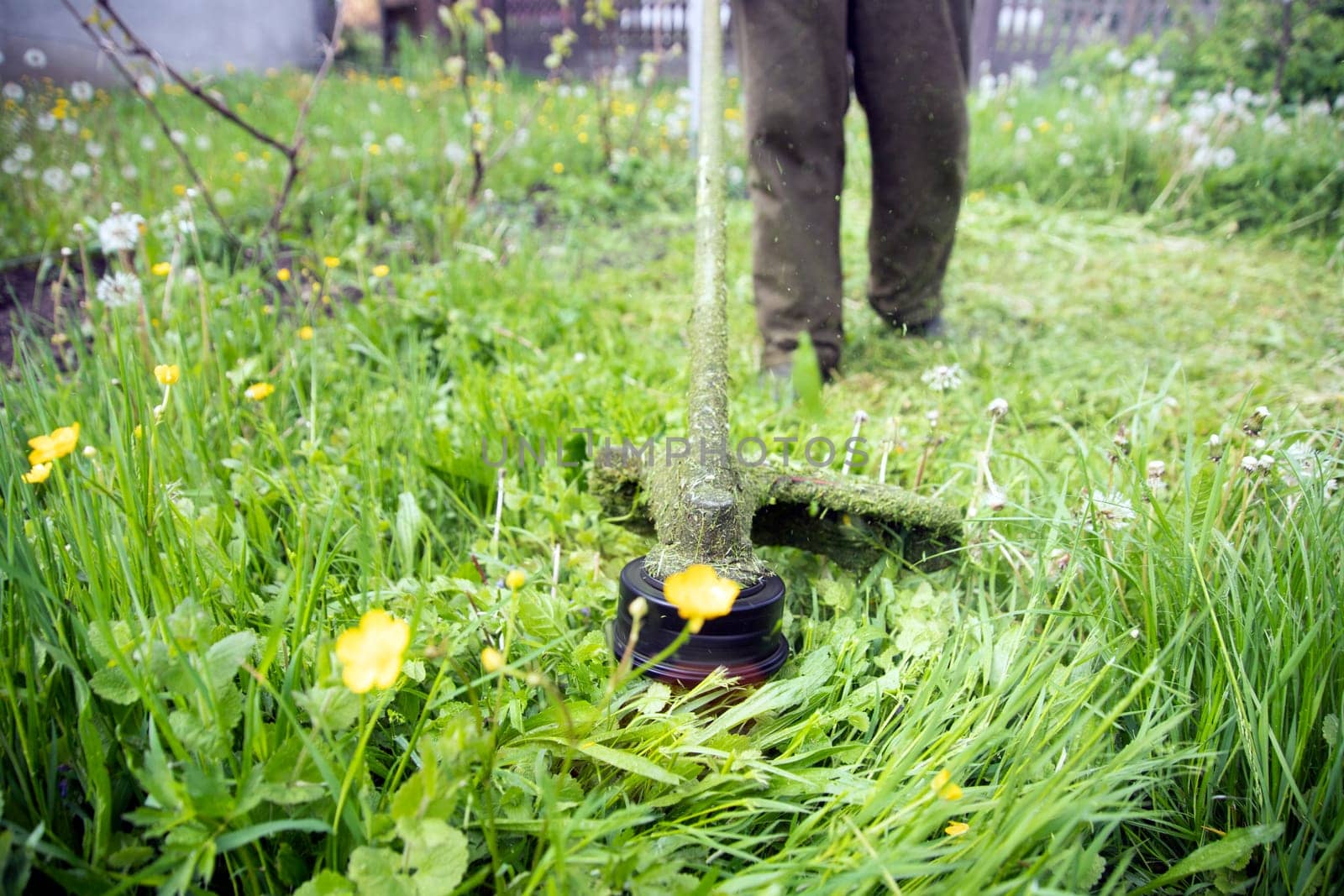 Mowing the grass with a lawn mower. Garden work concept background.