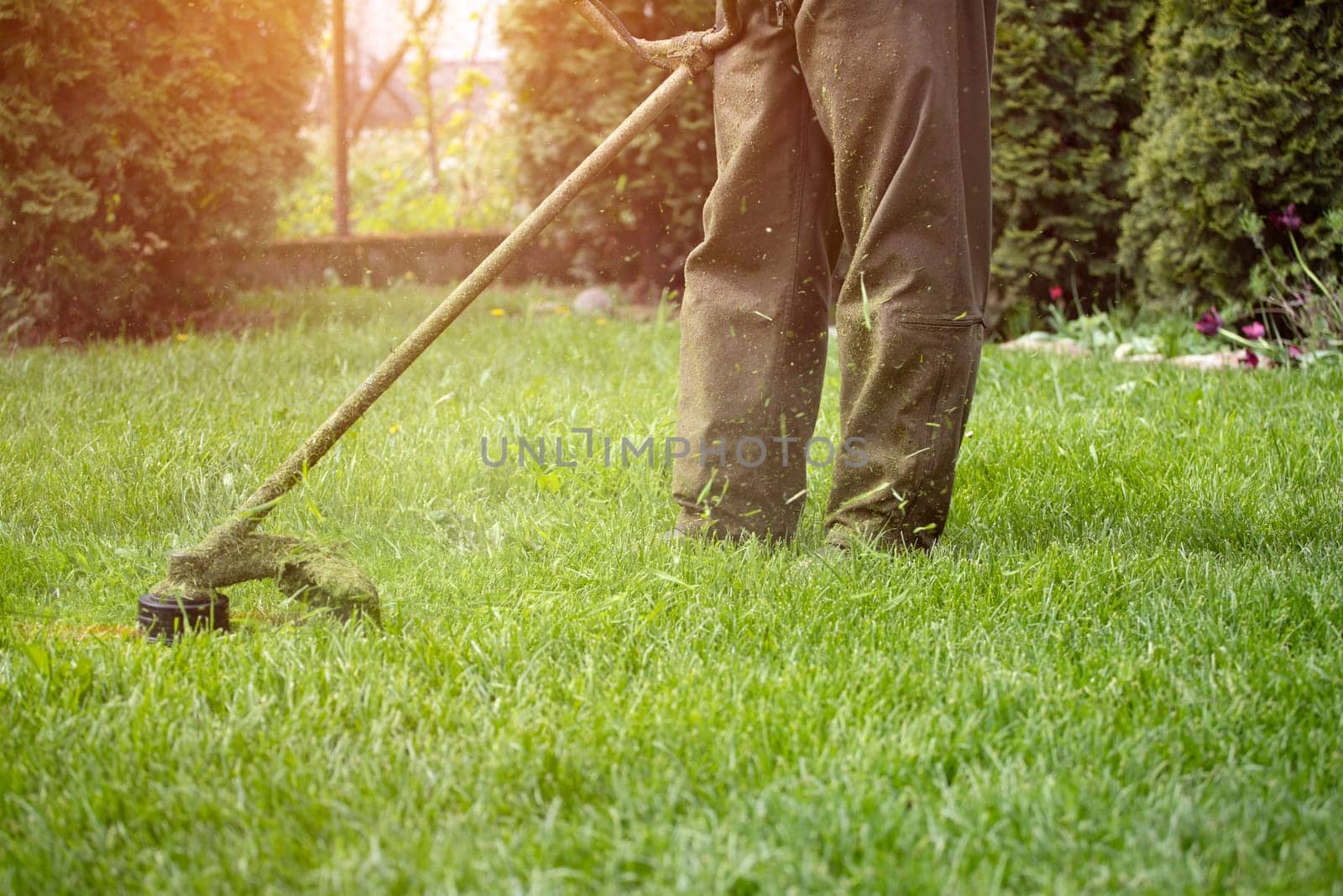 Mowing the grass with a lawn mower. Garden work concept background.
