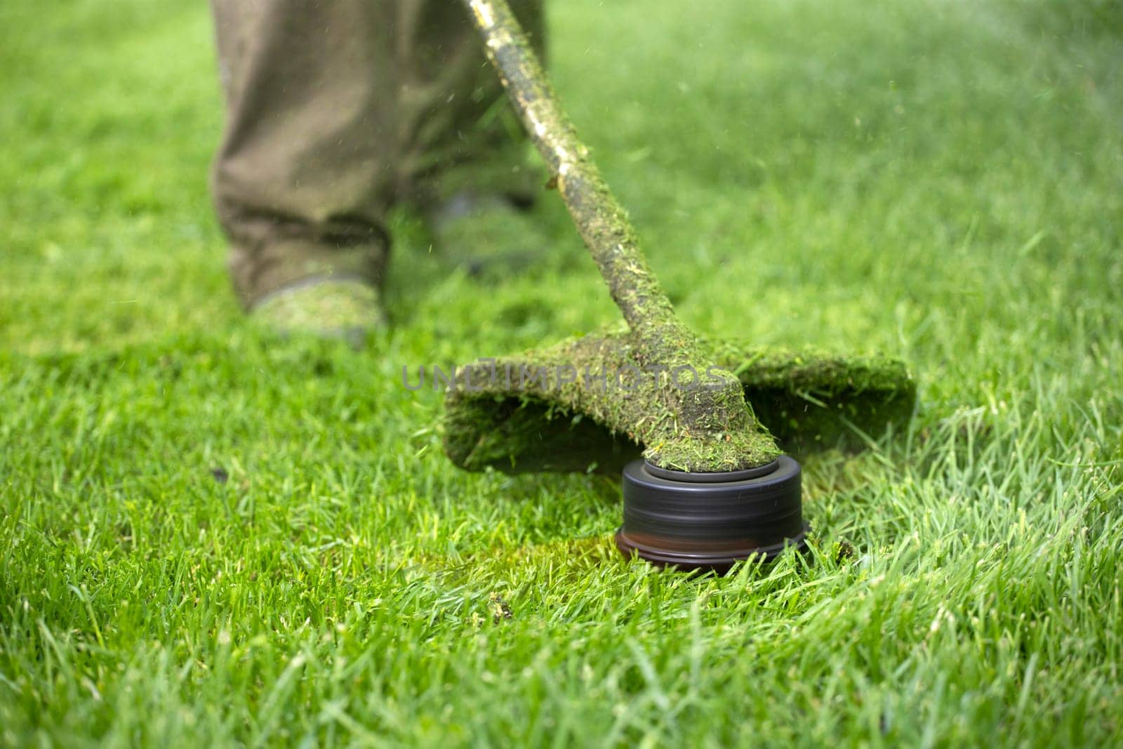 Mowing the grass with a lawn mower. Garden work concept background.