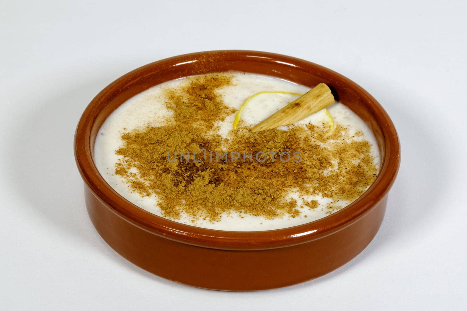 Dish of rice pudding with grated cinnamon, with lemon scratches