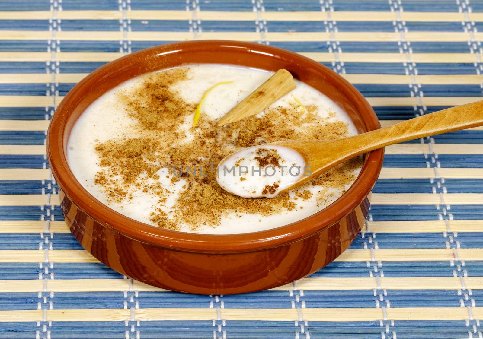 Dish of rice pudding with lemon scratches and with spoon