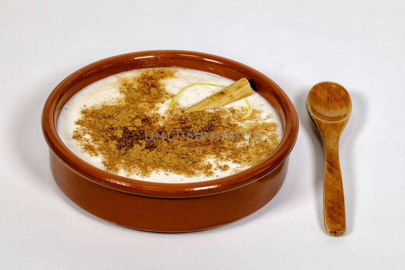 Dish of rice pudding with lemon scratches and with spoon