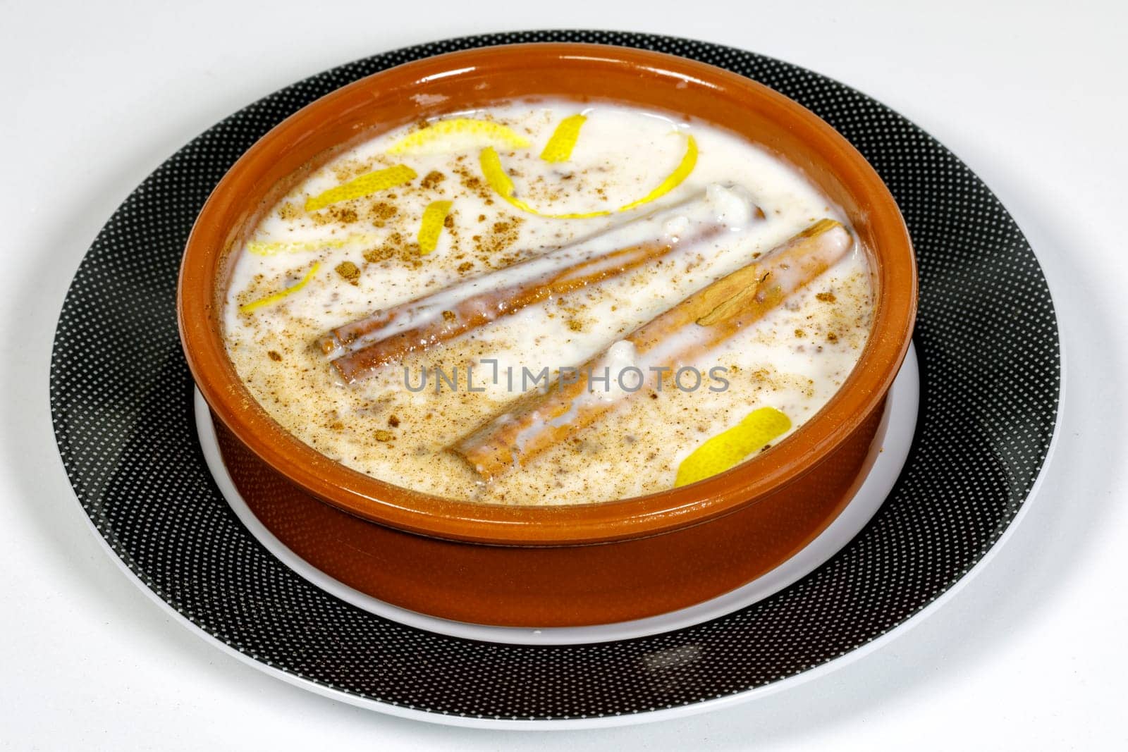 Dish of rice pudding with grated cinnamon, with lemon scratches