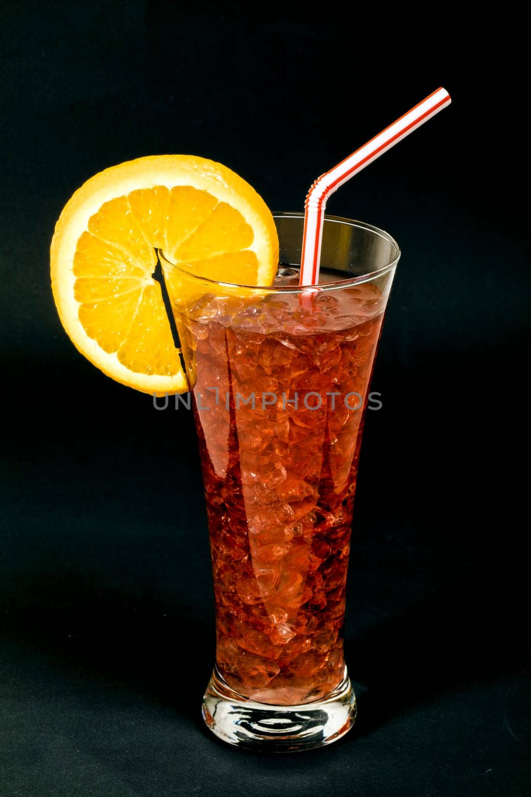 Refreshing typical sangria drink from Spain, with ice Orange slice on black background