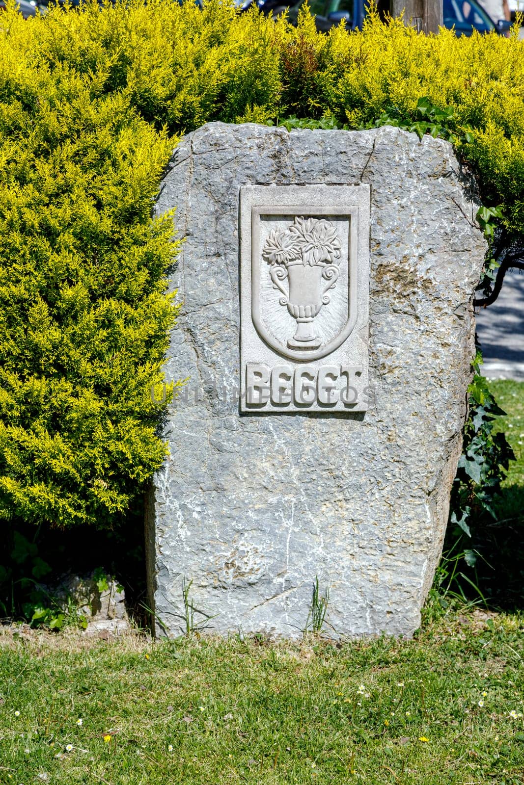 Stone flag at the entrance of the town's name and shield, Beget Spain