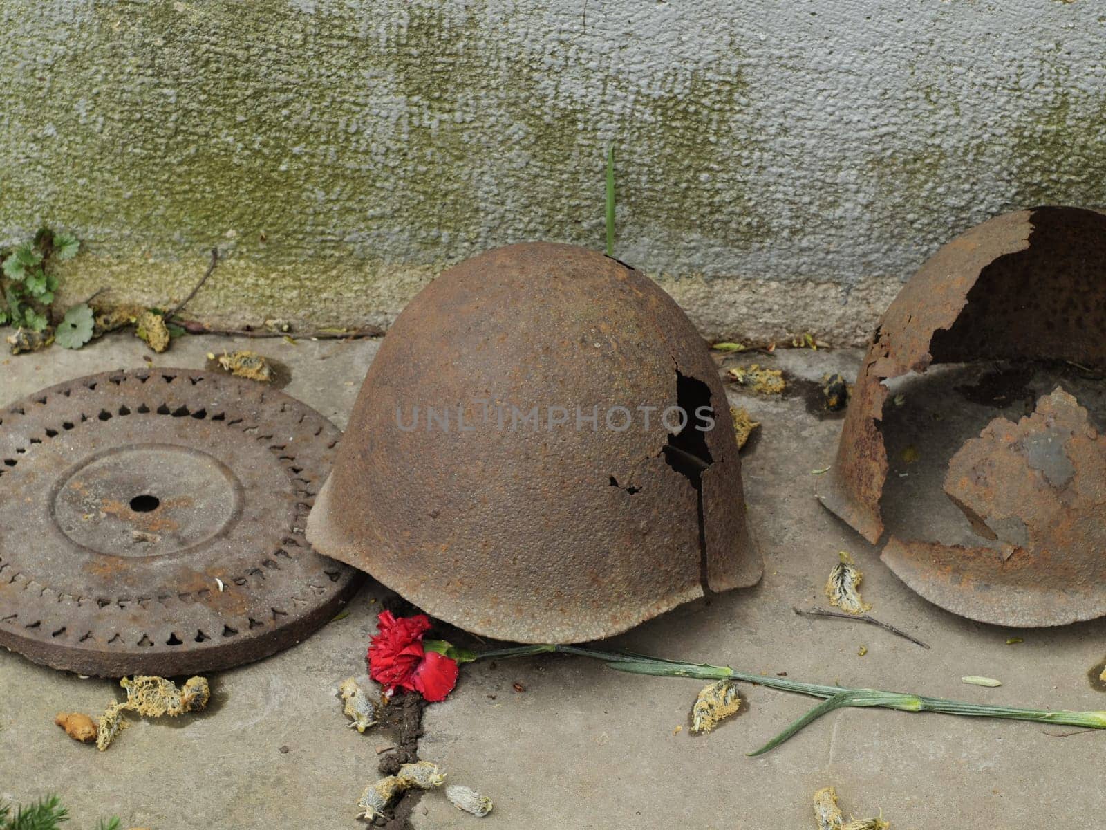 Old soldiers' iron helmets with holes traces of past battles on the memorial to the fallen soldiers of the Soviet army