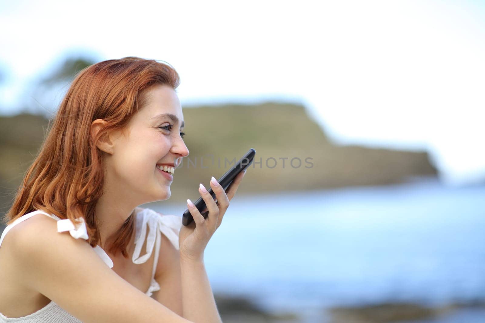 Happy tourist on the beach celebrating vacation raising arms