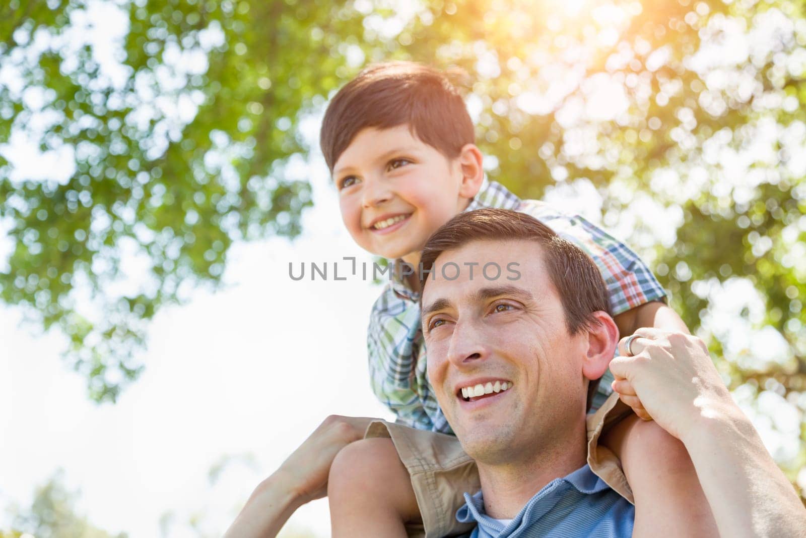 Mixed Race Father and Son Playing Piggyback Together in the Park.