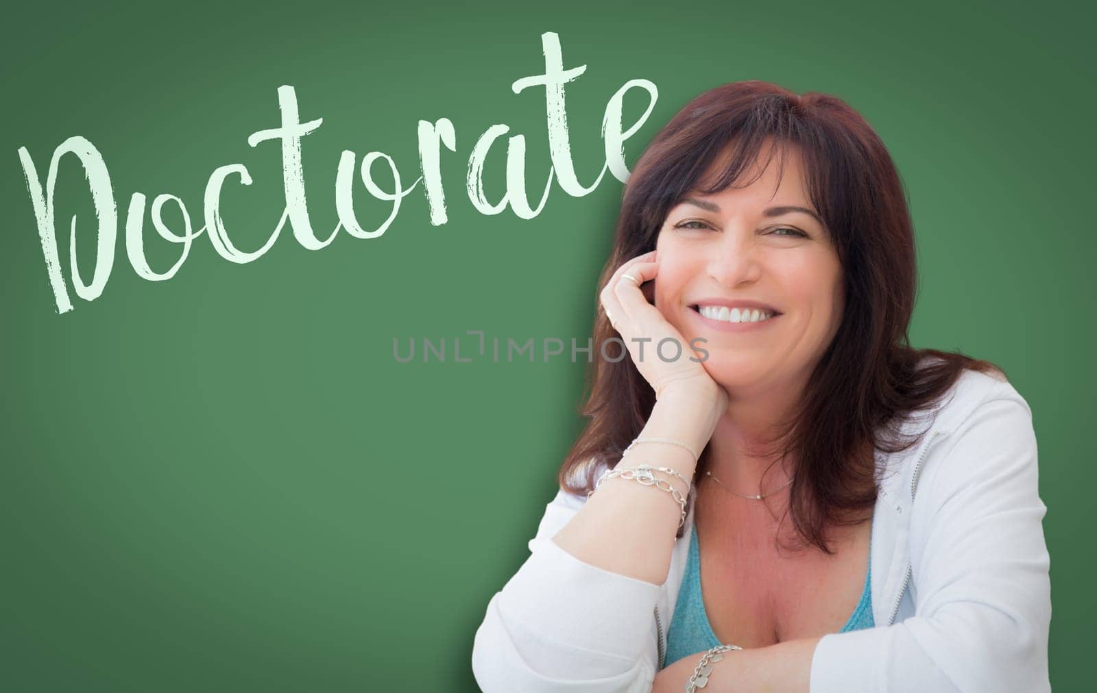 Doctorate Written On Green Chalkboard Behind Smiling Middle Aged Woman.