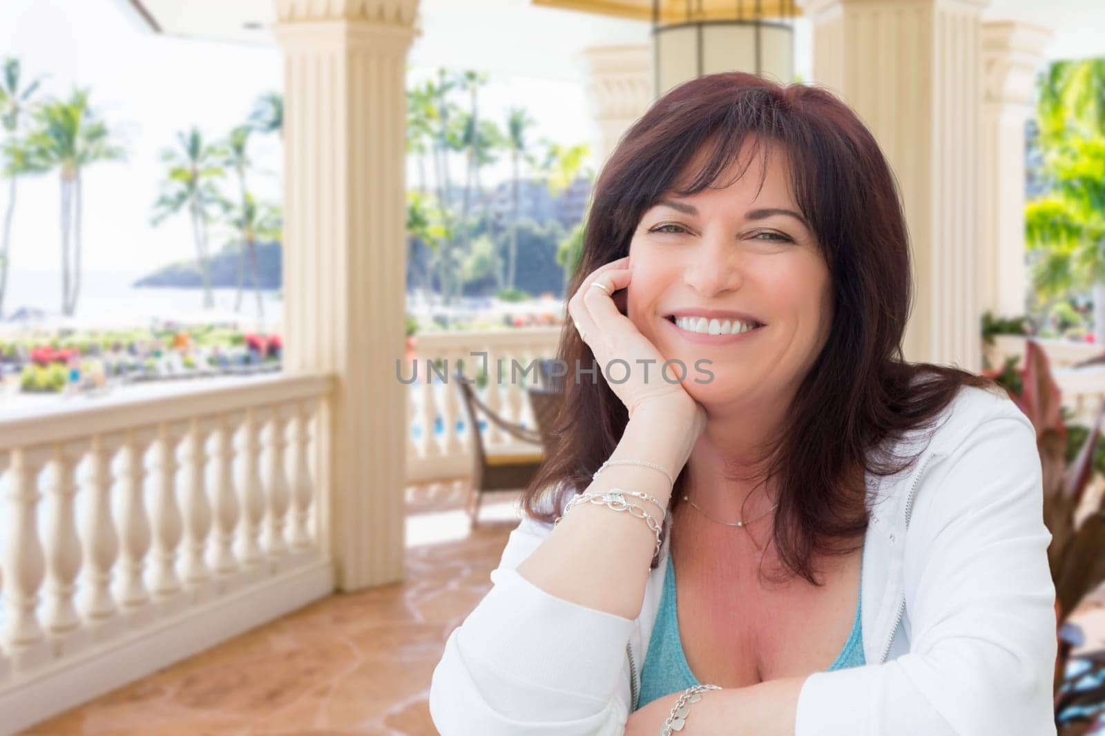 Attractive Middle Aged Woman Relaxing On Patio In A Tropical Travel Destination.