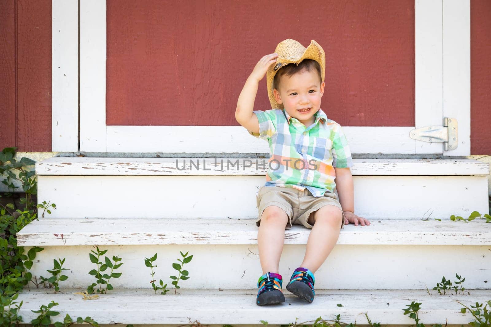 Young Mixed Race Chinese and Caucasian Boy Wearing Cowboy Hat Relaxing On The Steps