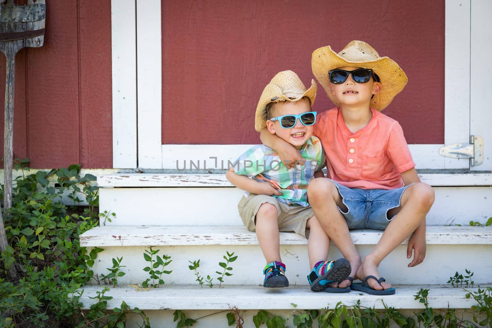 Mixed Race Chinese and Caucasian Young Brothers Having Fun Wearing Sunglasses and Cowboy Hats
