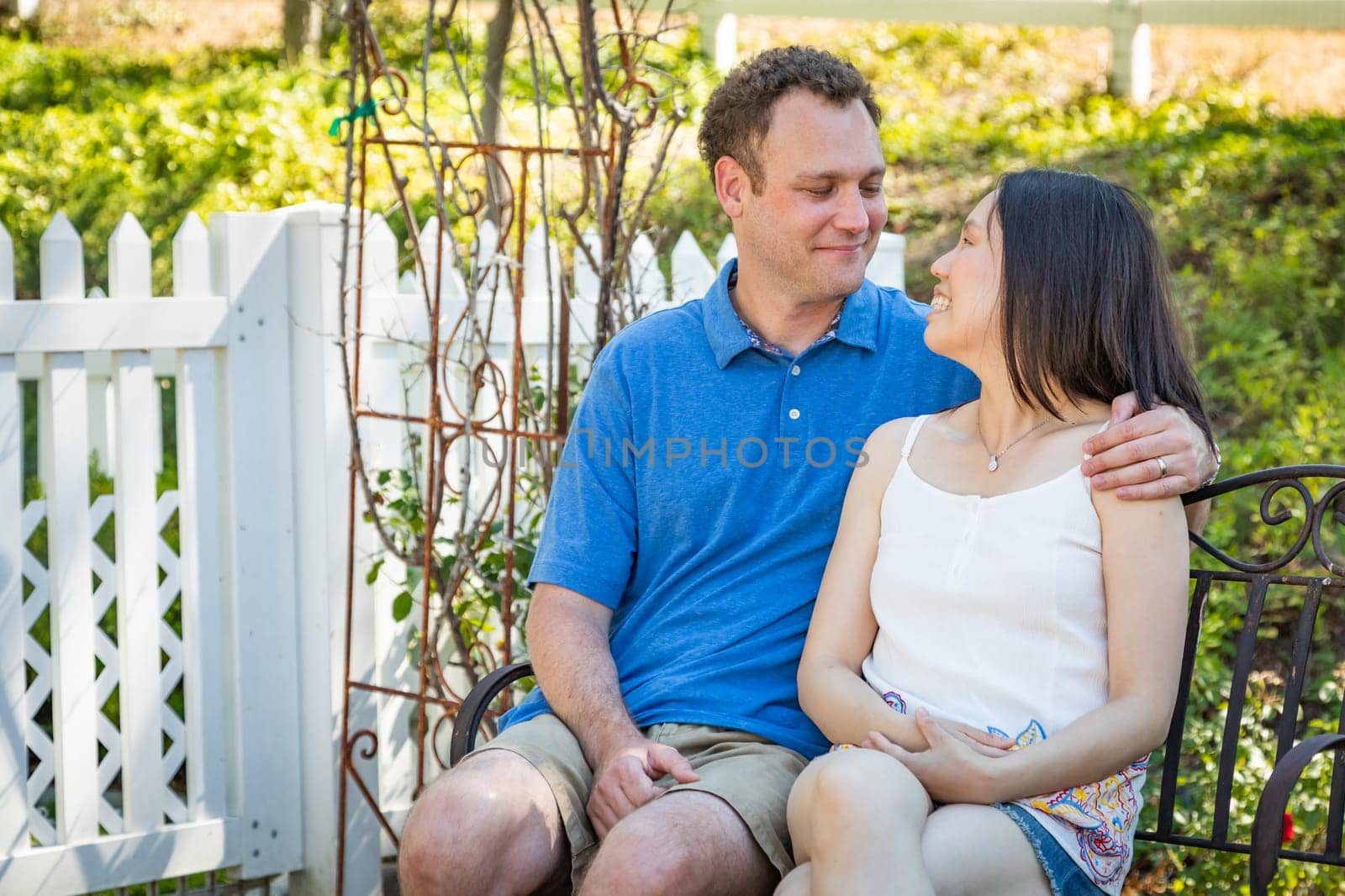 Young Caucasian Man and Chinese Woman Sitting On Bench