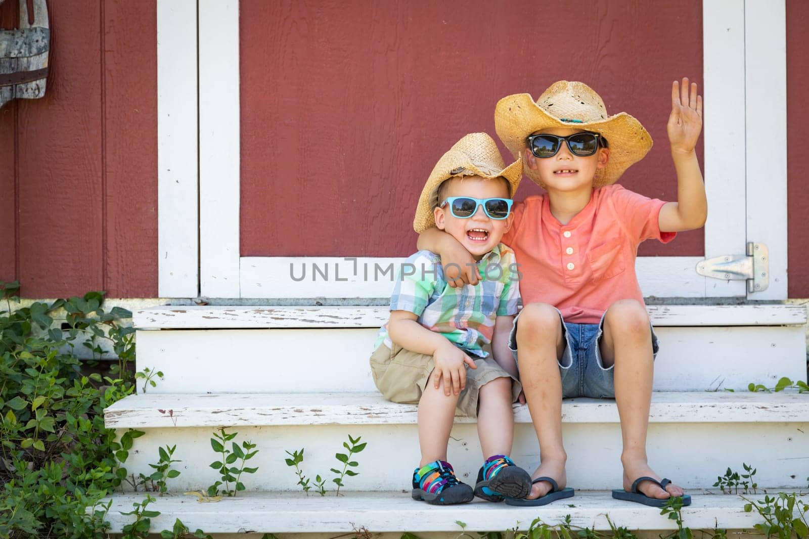 Mixed Race Chinese and Caucasian Young Brothers Having Fun Wearing Sunglasses and Cowboy Hats