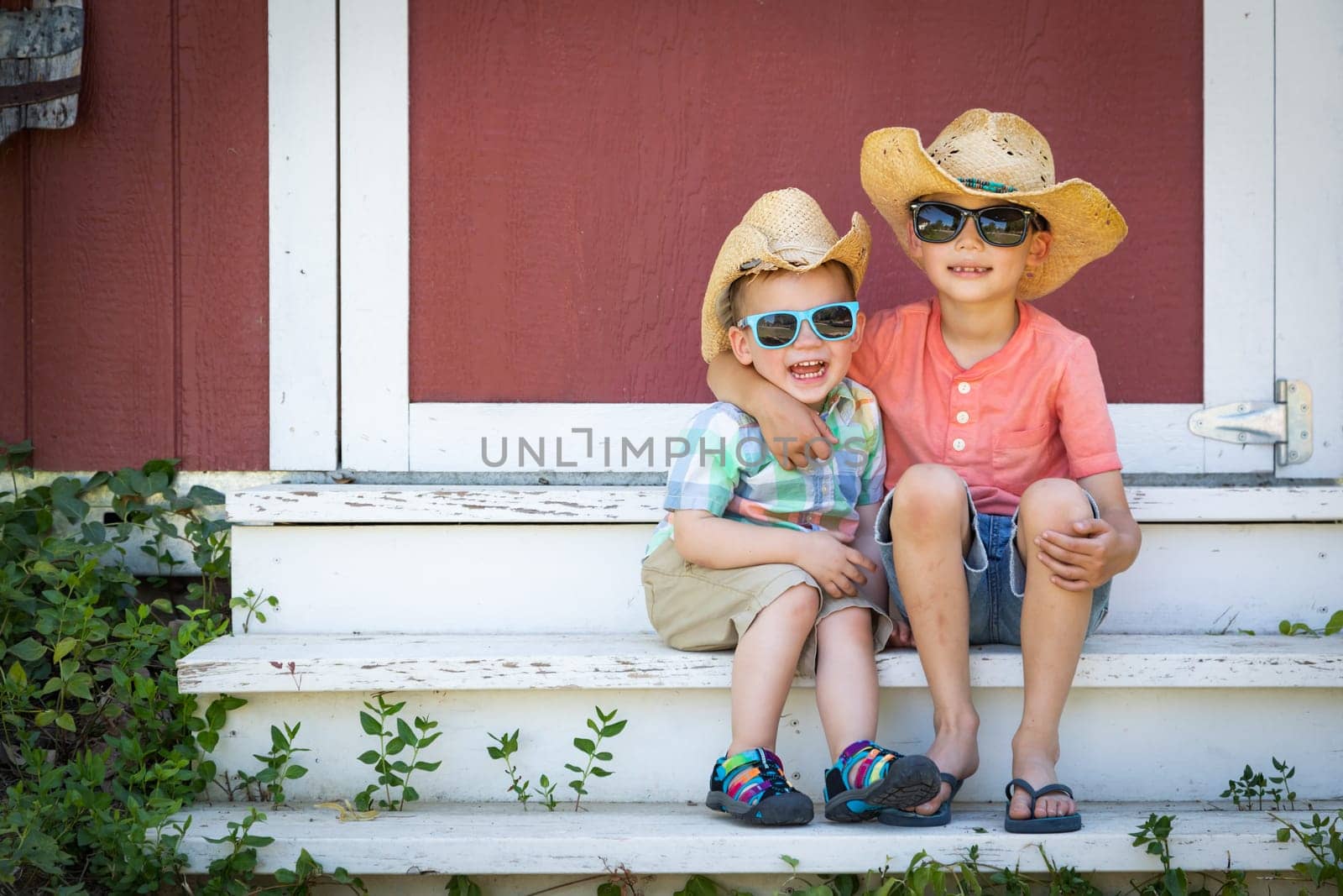 Mixed Race Chinese and Caucasian Young Brothers Having Fun Wearing Sunglasses and Cowboy Hats