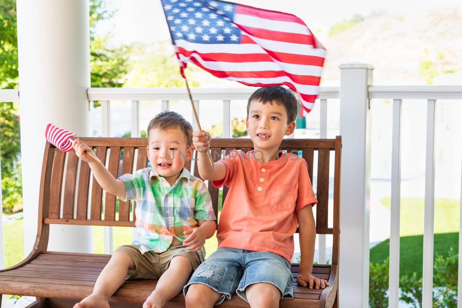 Young Mixed Race Chinese and Caucasian Brothers Playing With American Flags