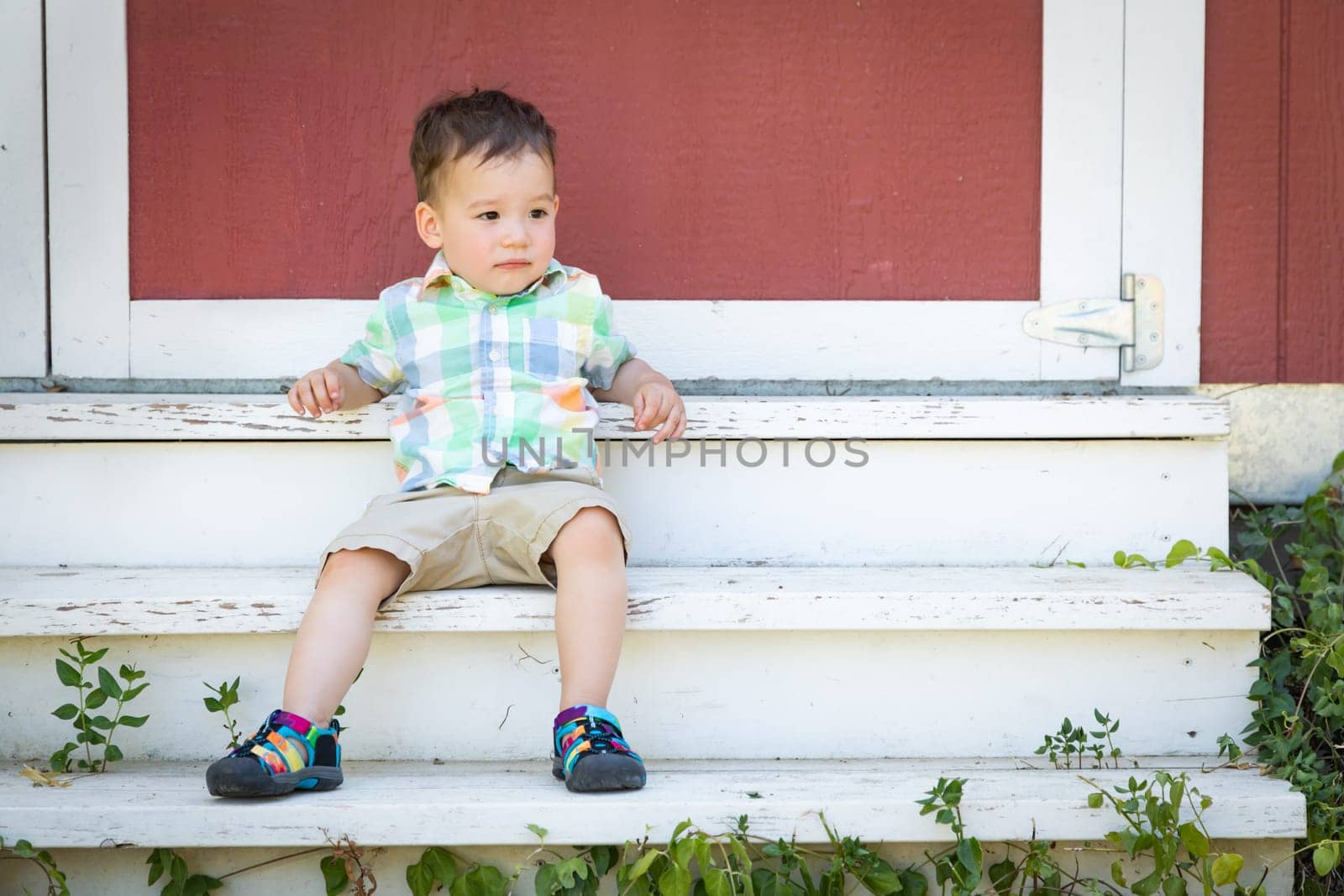 Young Mixed Race Chinese and Caucasian Boy Relaxing On The Steps