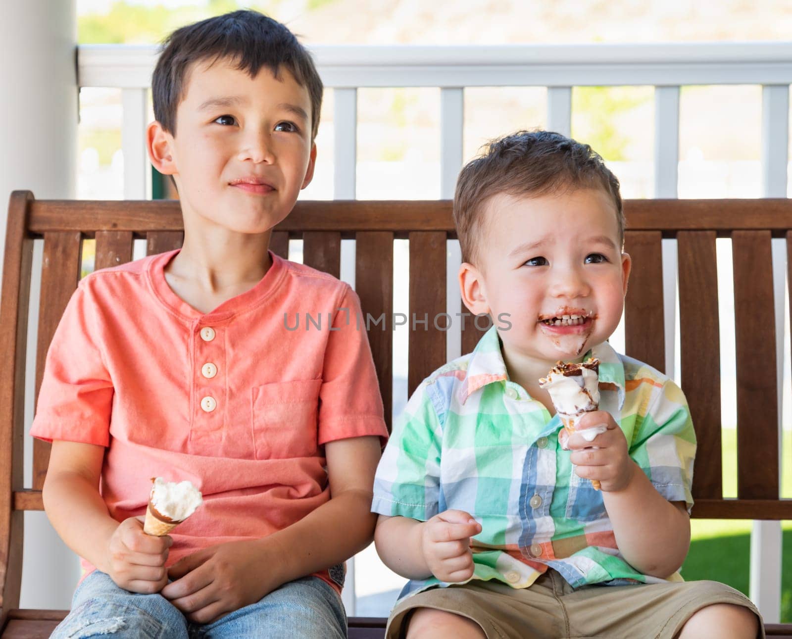 Young Mixed Race Chinese and Caucasian Brothers Enjoying Their Ice Cream Cones