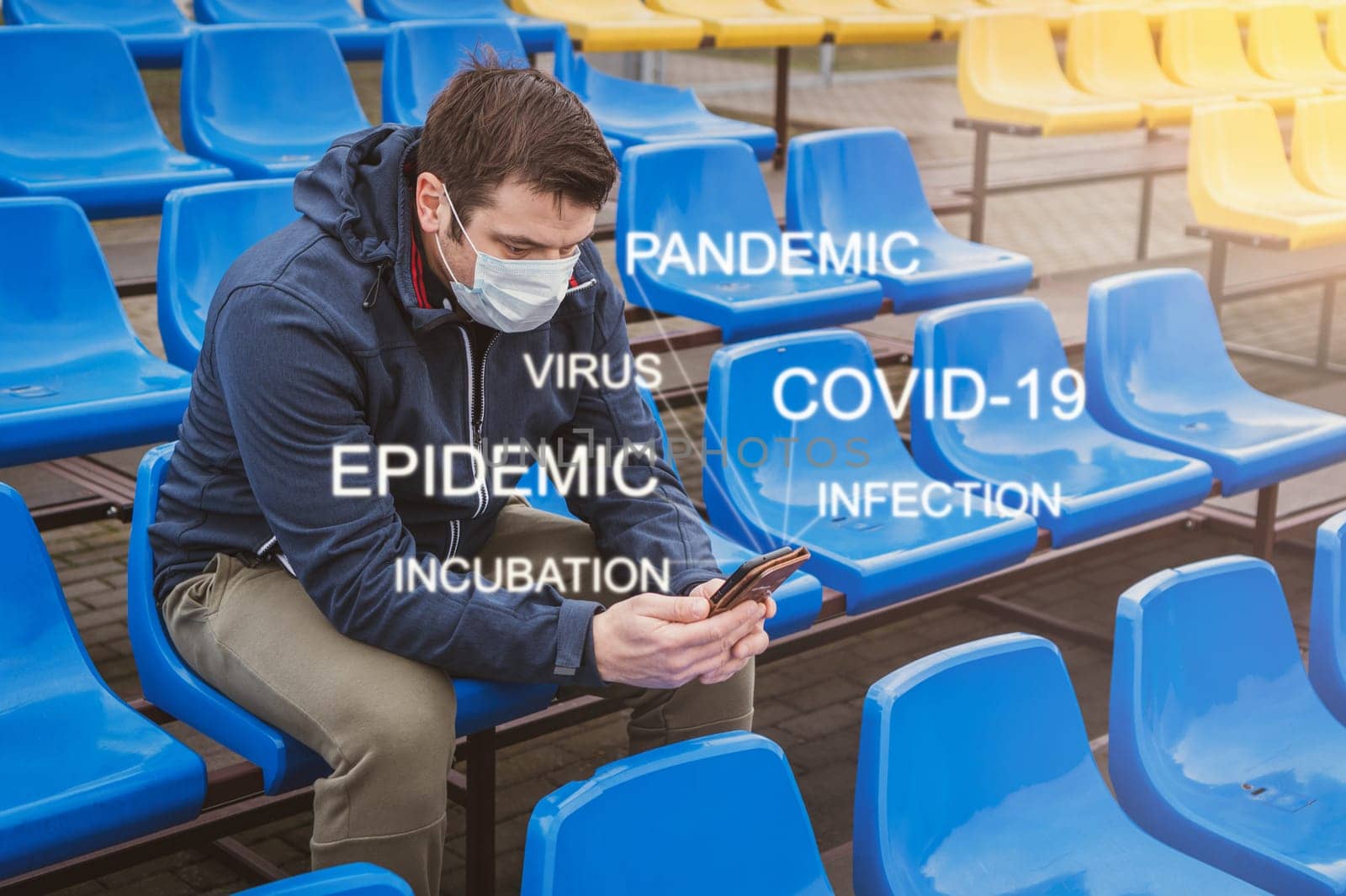 Man wears a mask against the coronavirus while reading a messages or news about global pandemic on his cell phone.