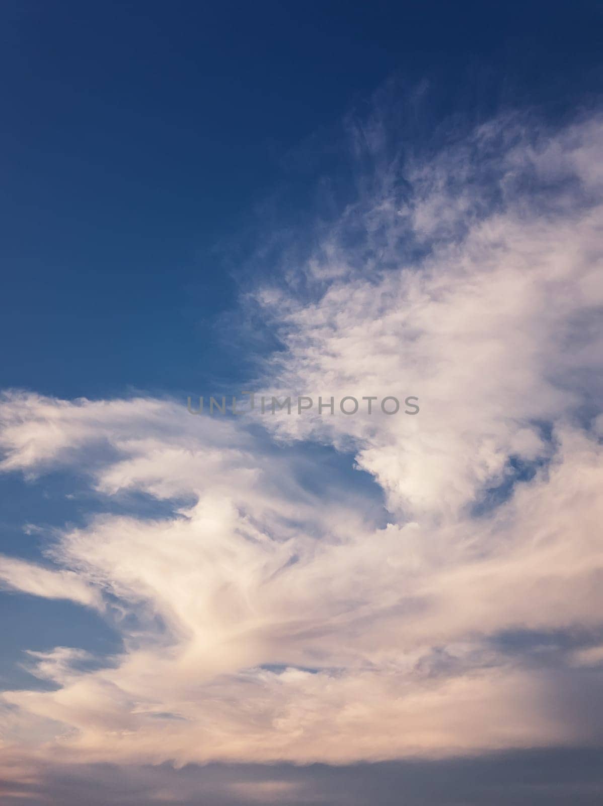 Tranquil evening cloudscape scene over the blue sky. Fluffy white clouds aerial composition. Misty overcast cumulus shapes, abstract nebula textures. Air fresheners, celestial beauty, vertical background