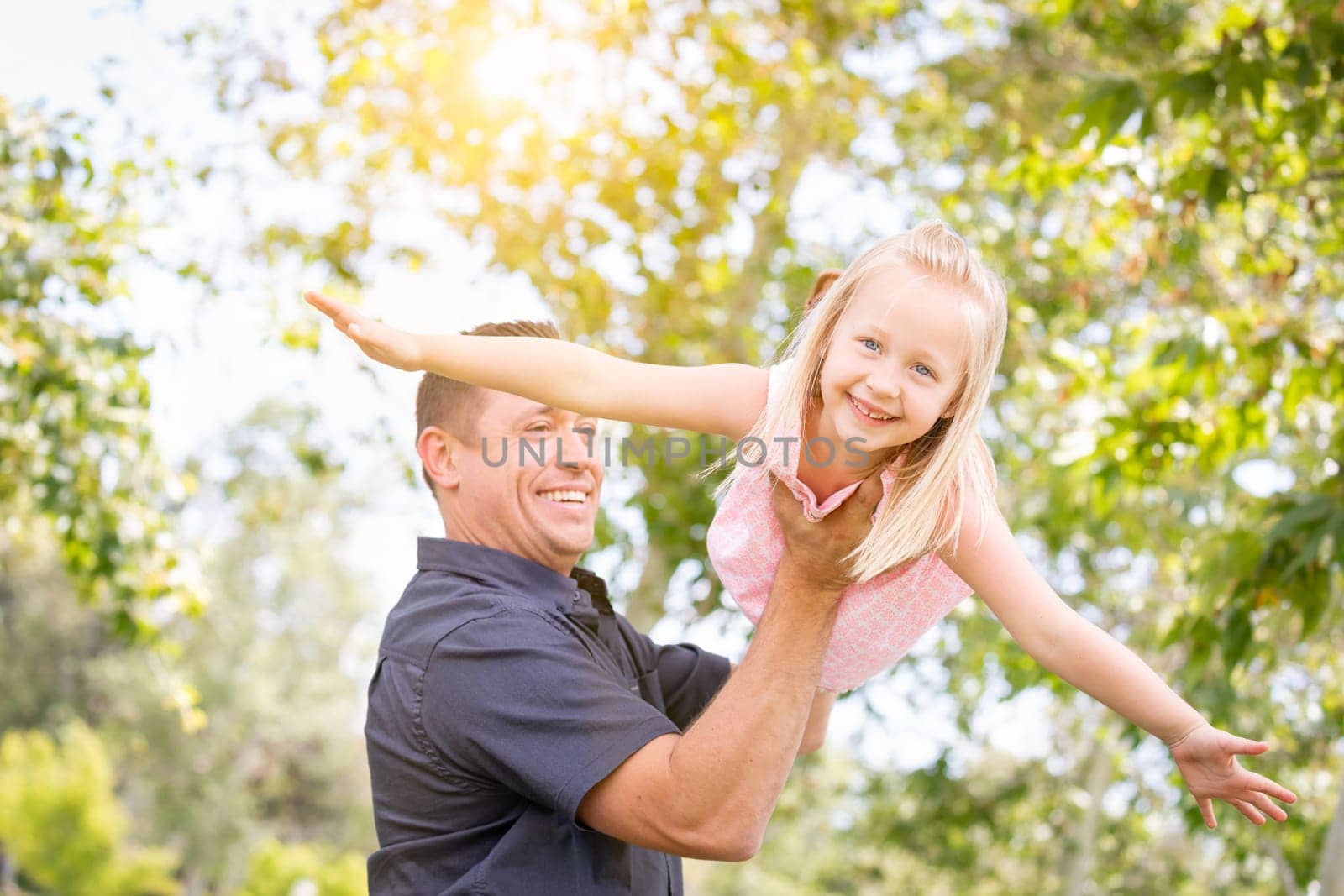 Young Caucasian Father and Daughter Having Fun At The Park.