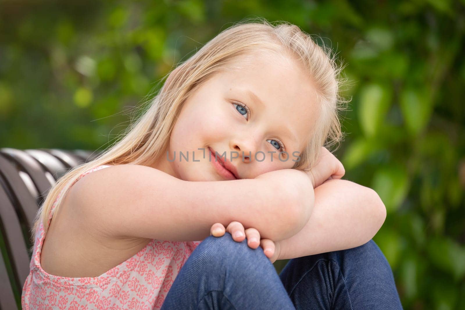 Pretty Young Caucasian Girl Portrait Sitting On The Bench At The Park.