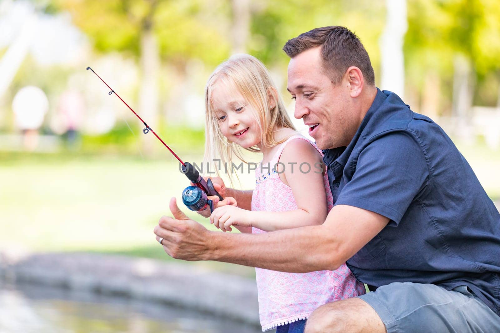 Young Caucasian Father and Daughter Having Fun Fishing At The Lake.