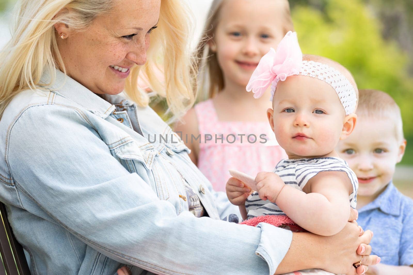 Young Caucasian Mother and Children At The Park.