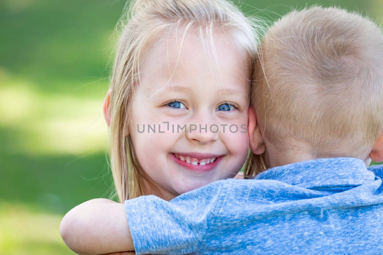 Young Brother and Sister Hugging At The Park.