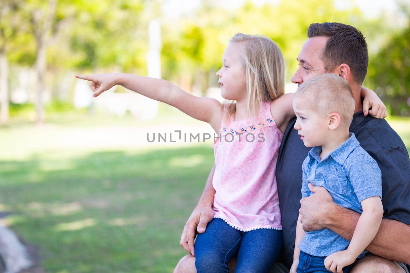 Young Caucasian Dad, Son and Daughter Having Fun In The Park.