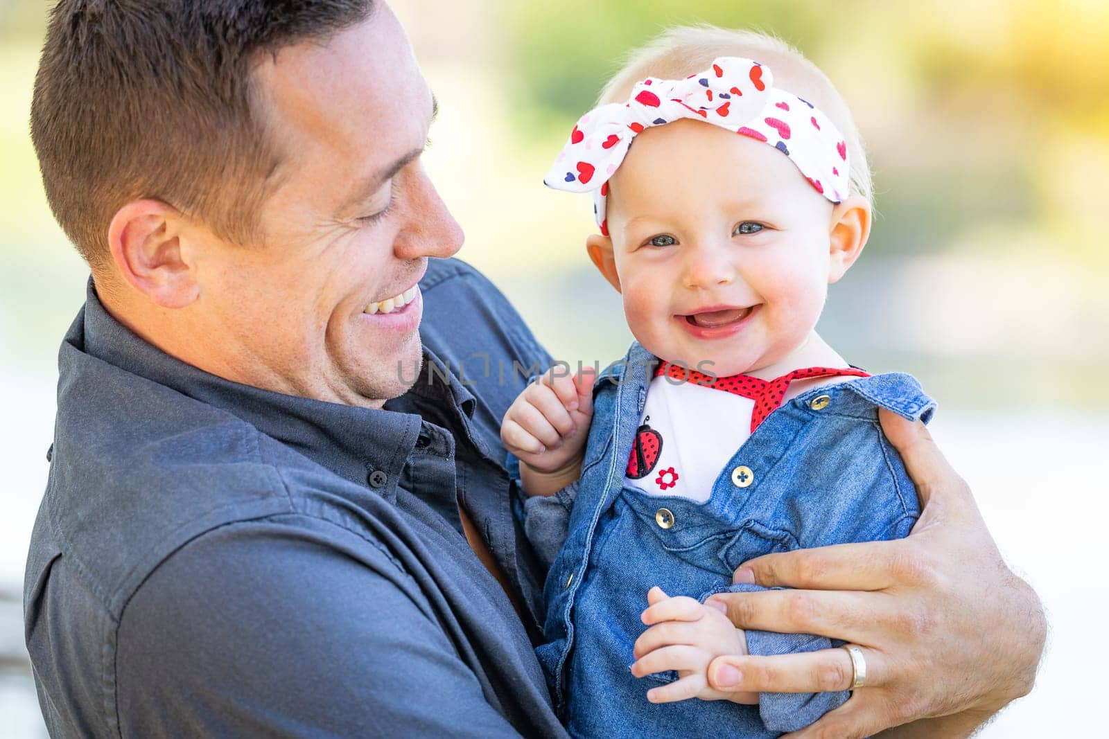 Young Caucasian Father and Baby Girl At The Park.