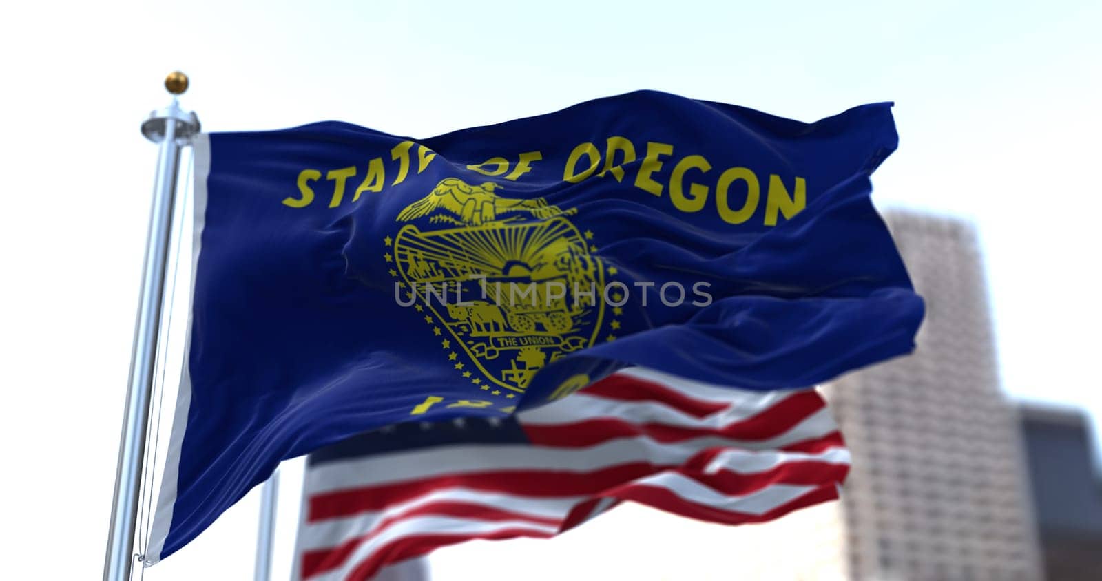 The flags of the Oregon state and United States waving in the wind. Democracy and independence. American state.
