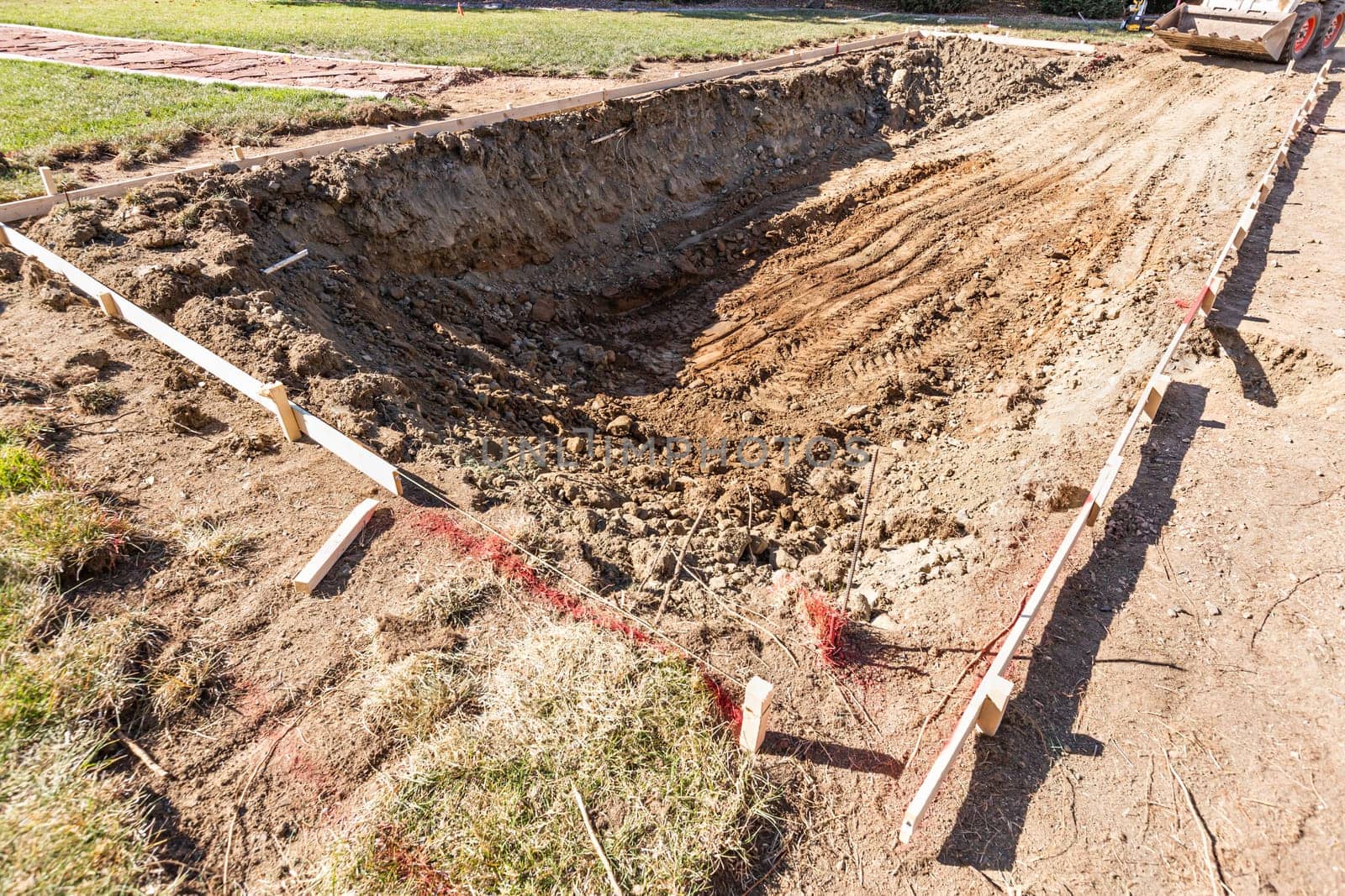 Freshly Dug Hole In Yard Preparing For Swimming Pool Installation.