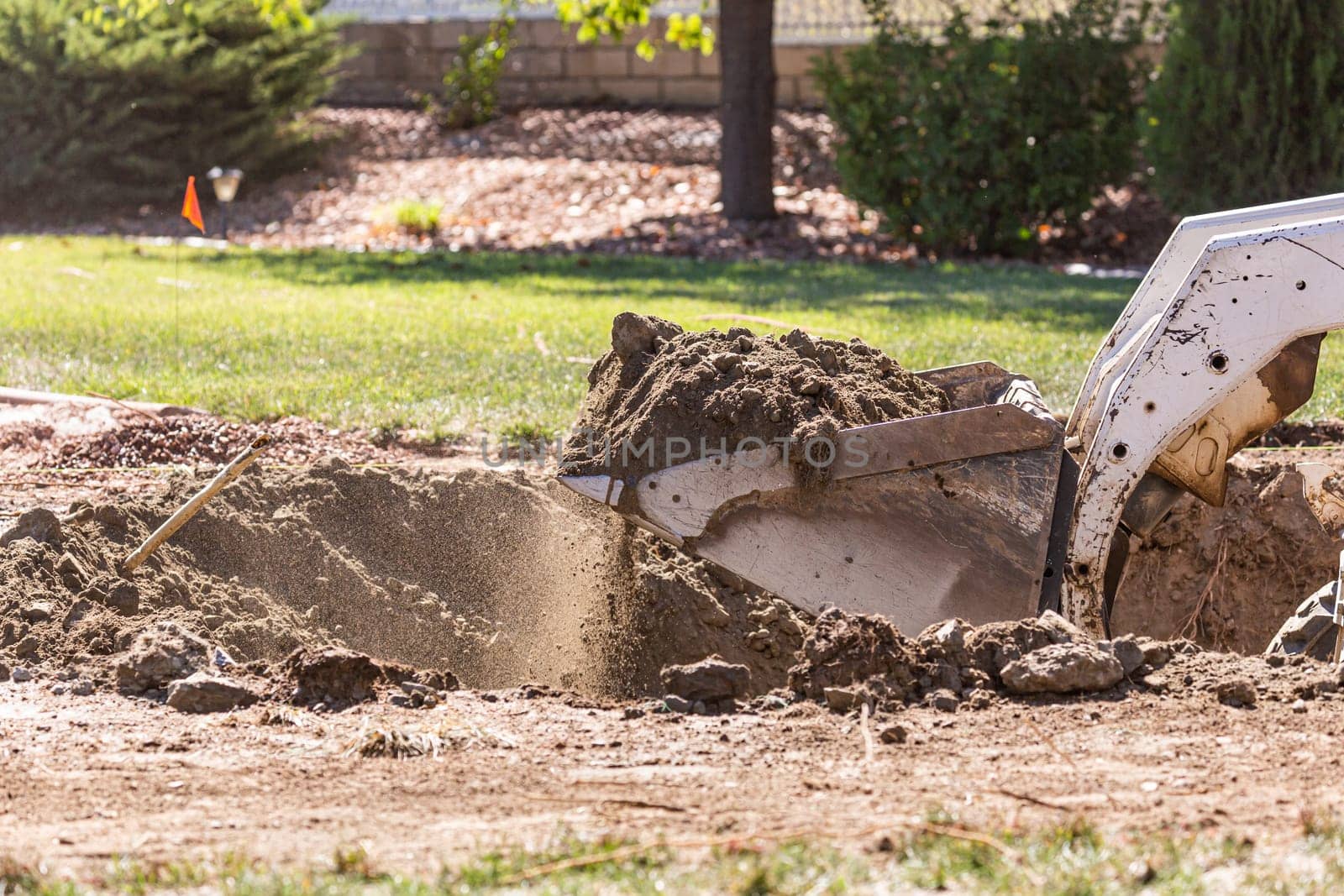 Small Bulldozer Digging In Yard For Pool Installation.