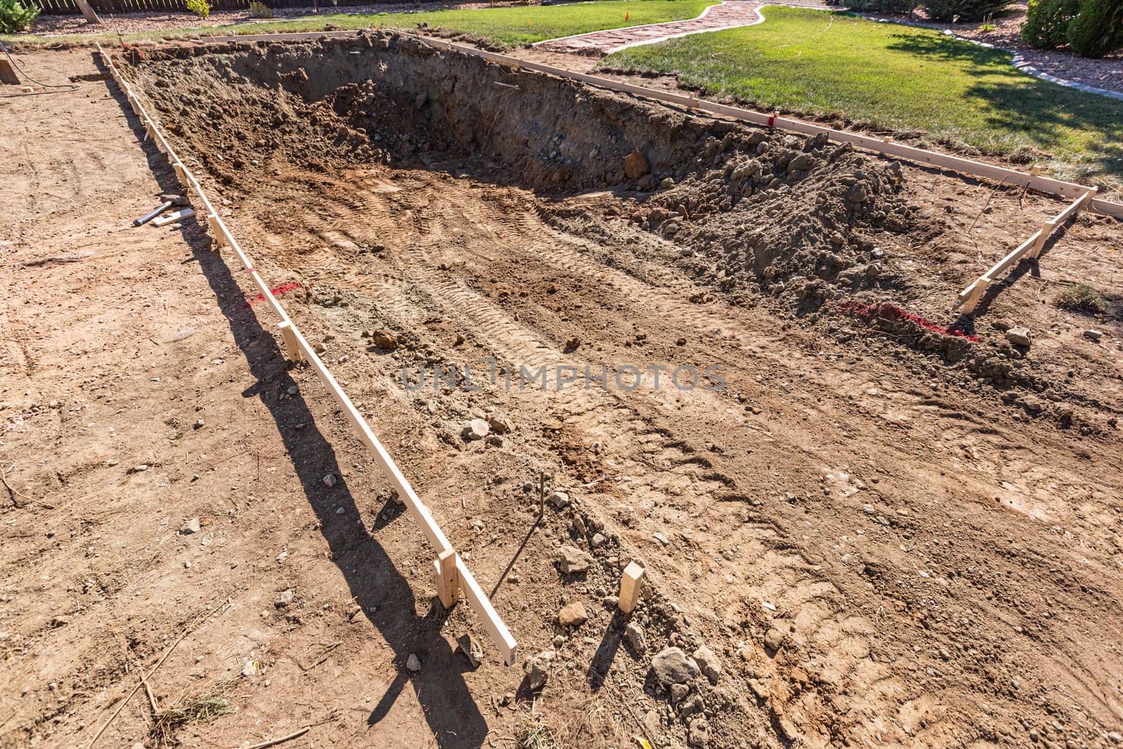 Freshly Dug Hole In Yard Preparing For Swimming Pool Installation.