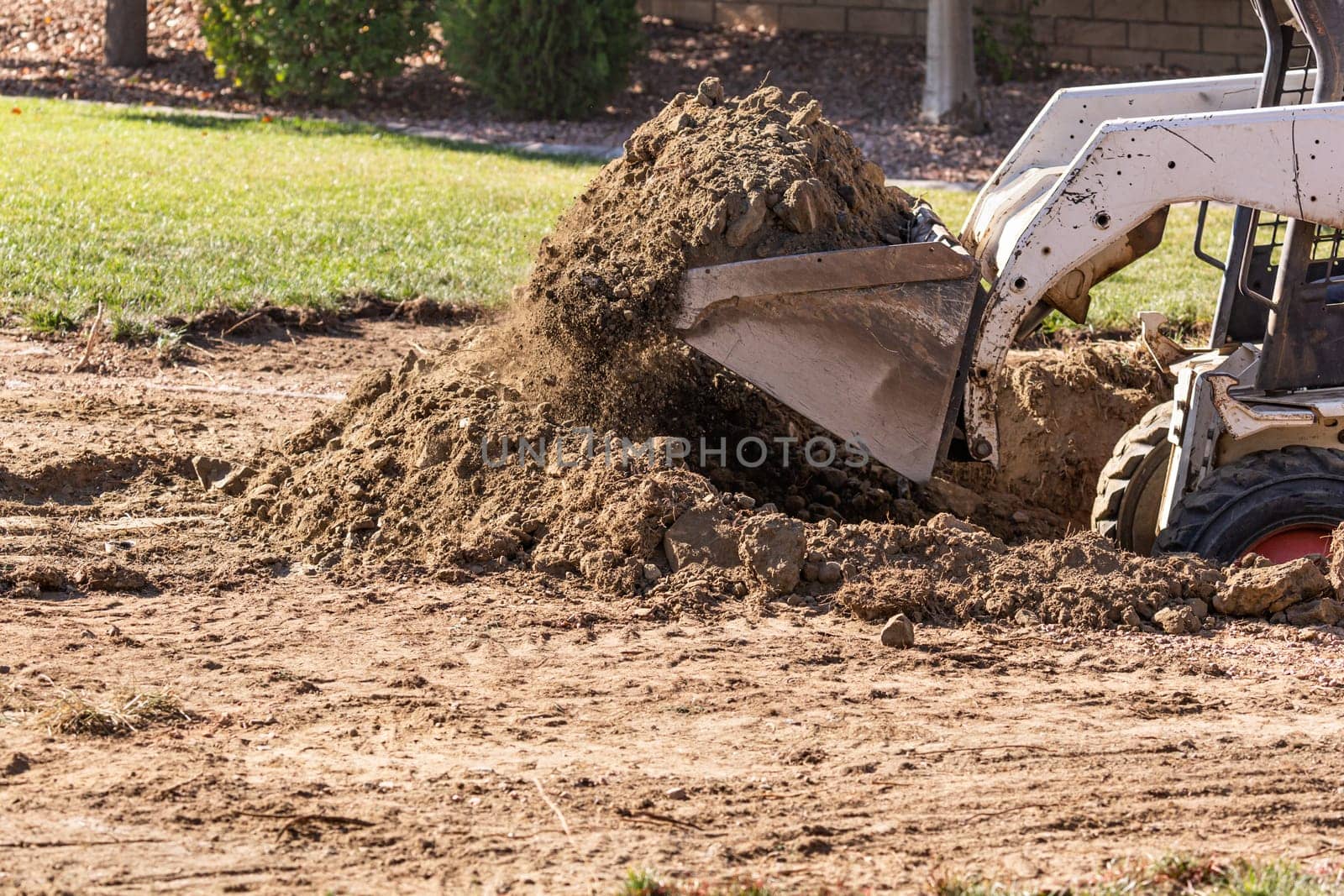 Small Bulldozer Digging In Yard For Pool Installation.