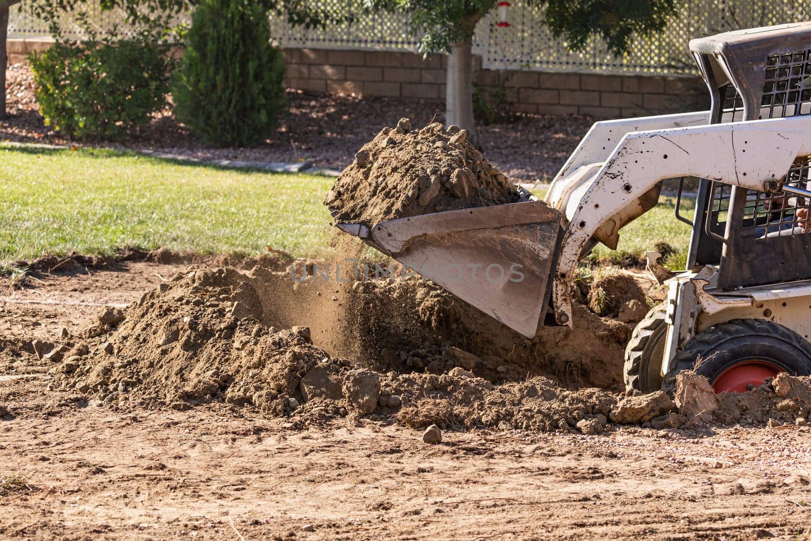 Small Bulldozer Digging In Yard For Pool Installation.