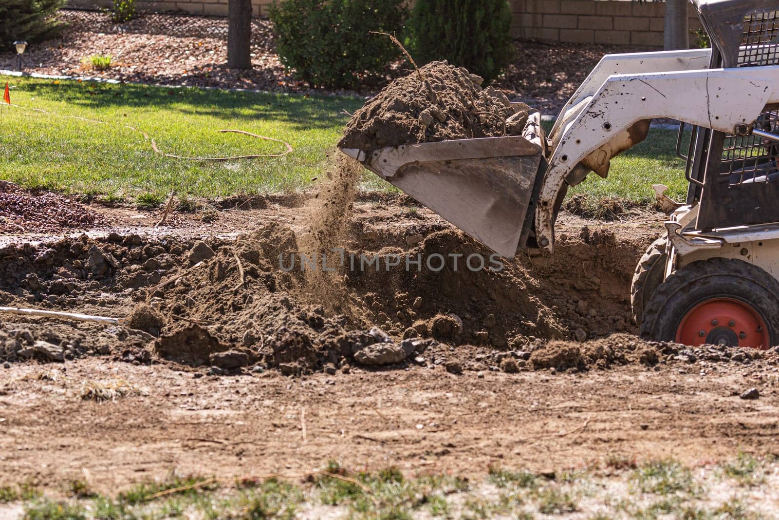 Small Bulldozer Digging In Yard For Pool Installation.