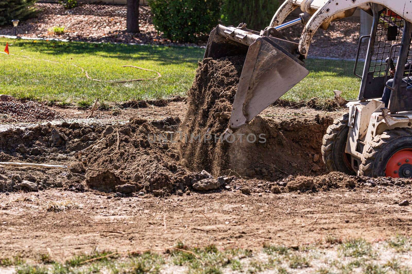 Small Bulldozer Digging In Yard For Pool Installation.
