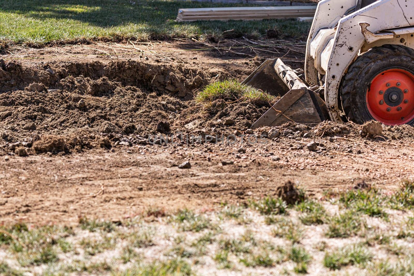 Small Bulldozer Digging In Yard For Pool Installation.