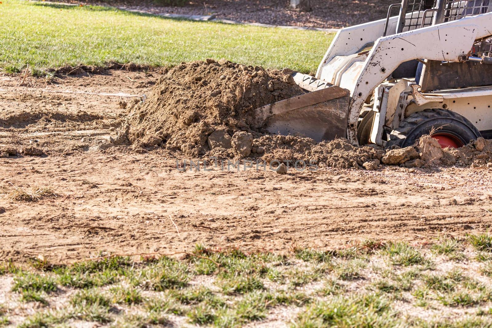 Small Bulldozer Digging In Yard For Pool Installation.