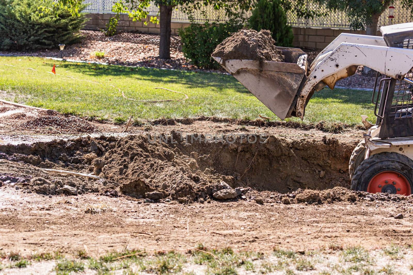 Small Bulldozer Digging In Yard For Pool Installation.