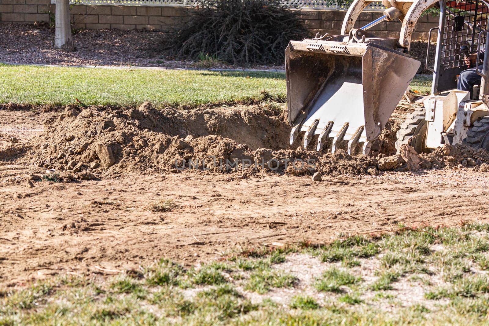 Small Bulldozer Digging In Yard For Pool Installation.