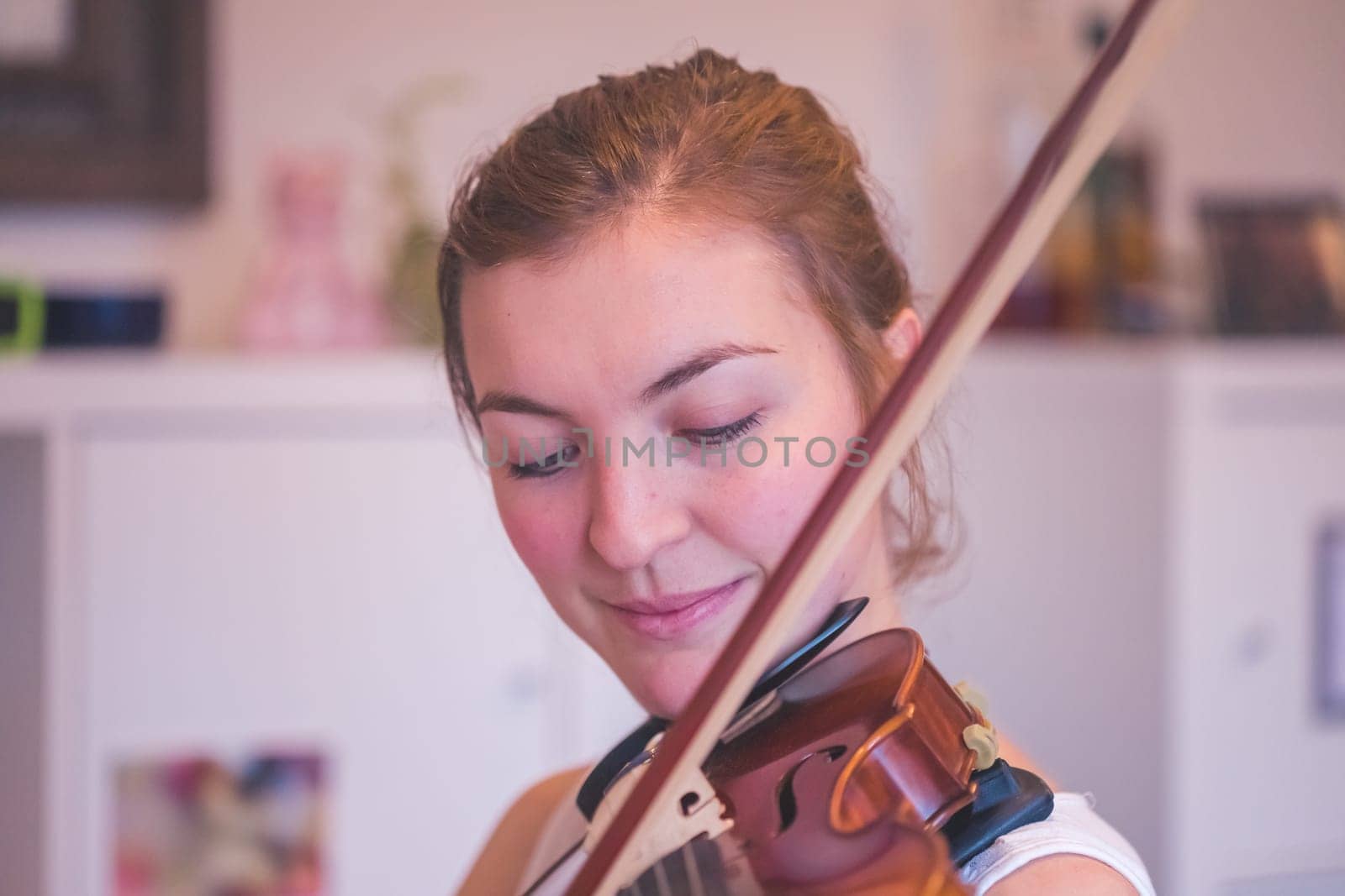 Pretty young girl practices on her violin, acoustic music