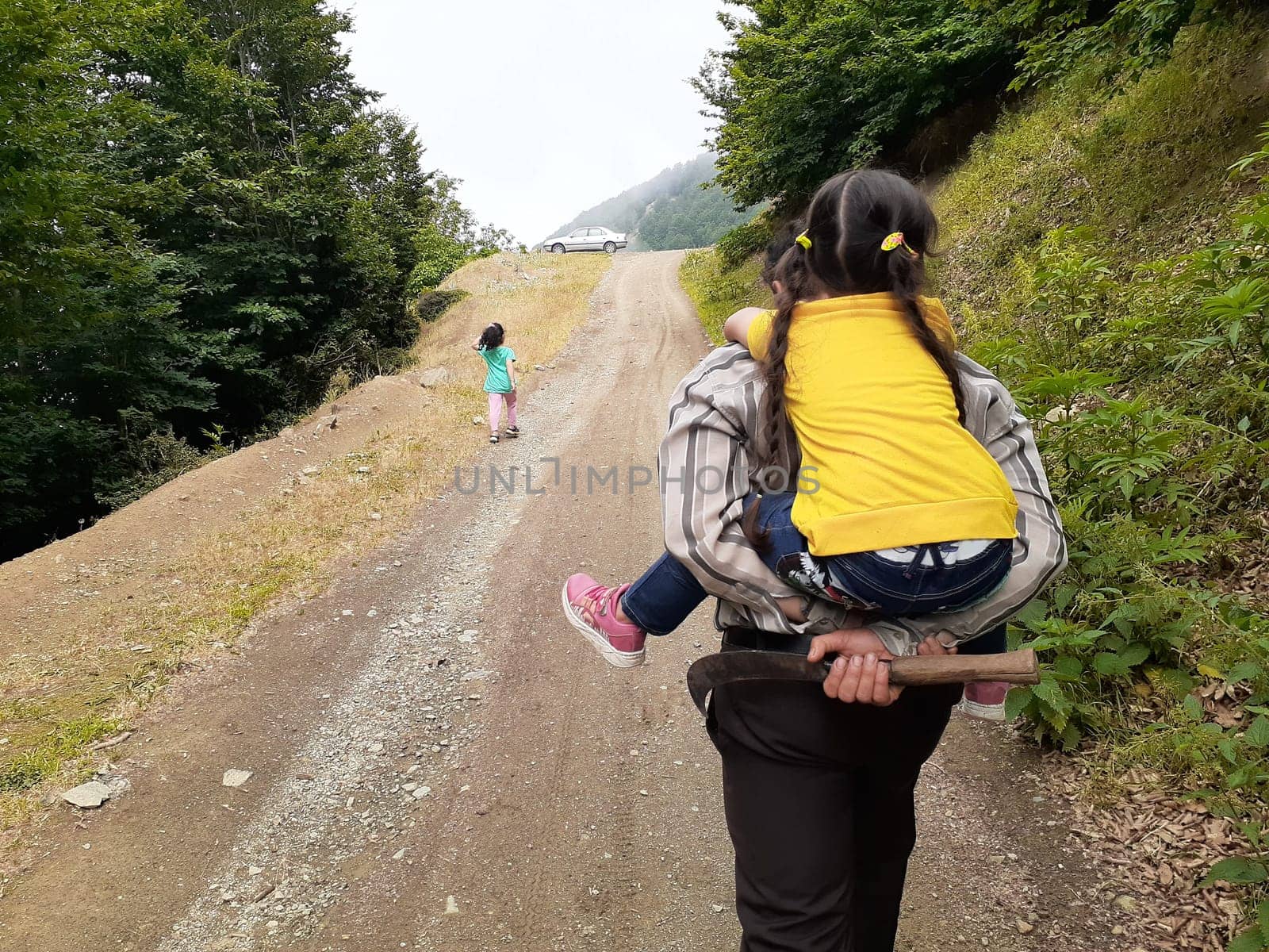lovely daughter sitting on the  back of her father on the road-family concept