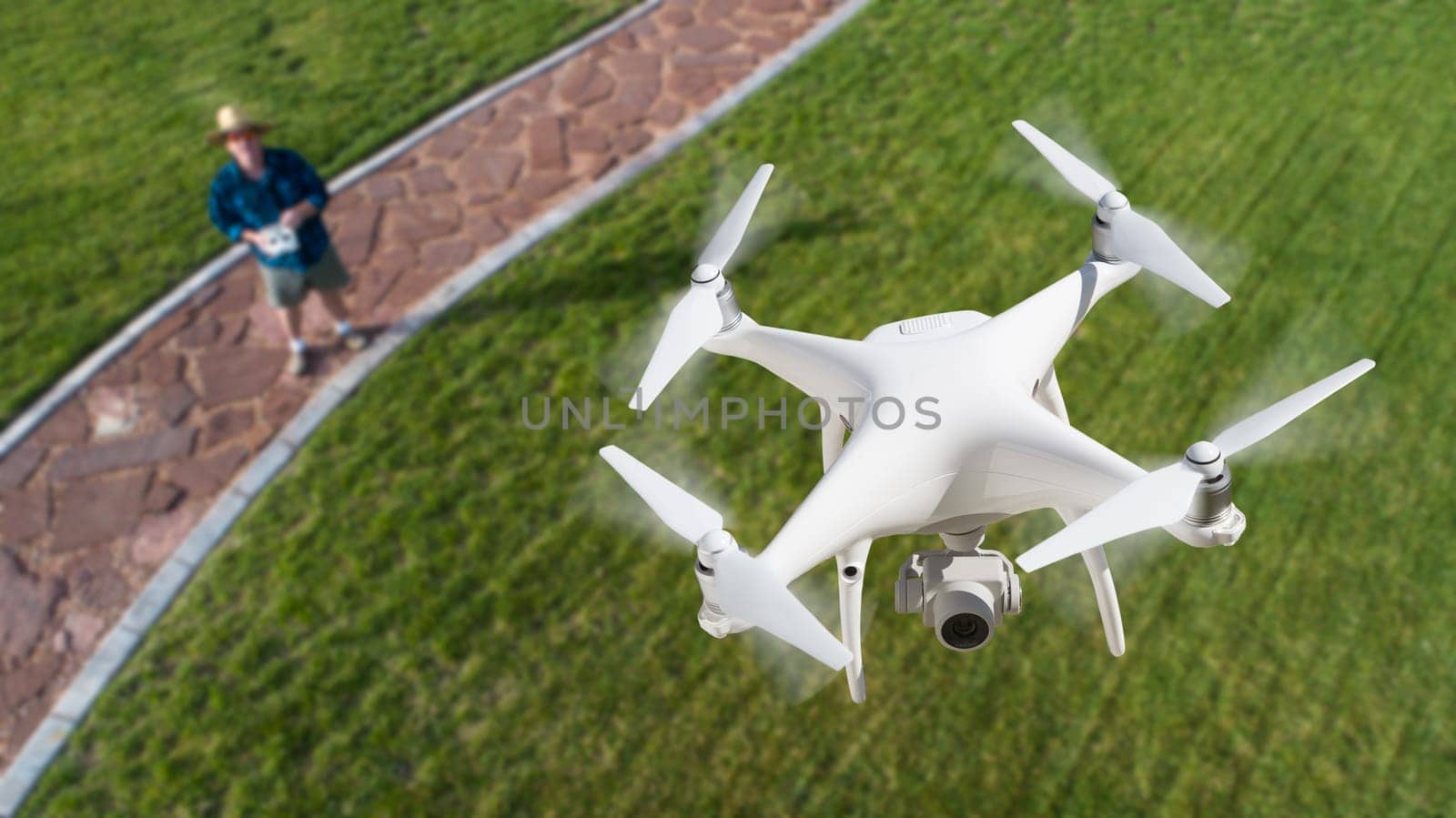 Drone Quadcopter (UAV) In Air Above Pilot With Remote Controller.