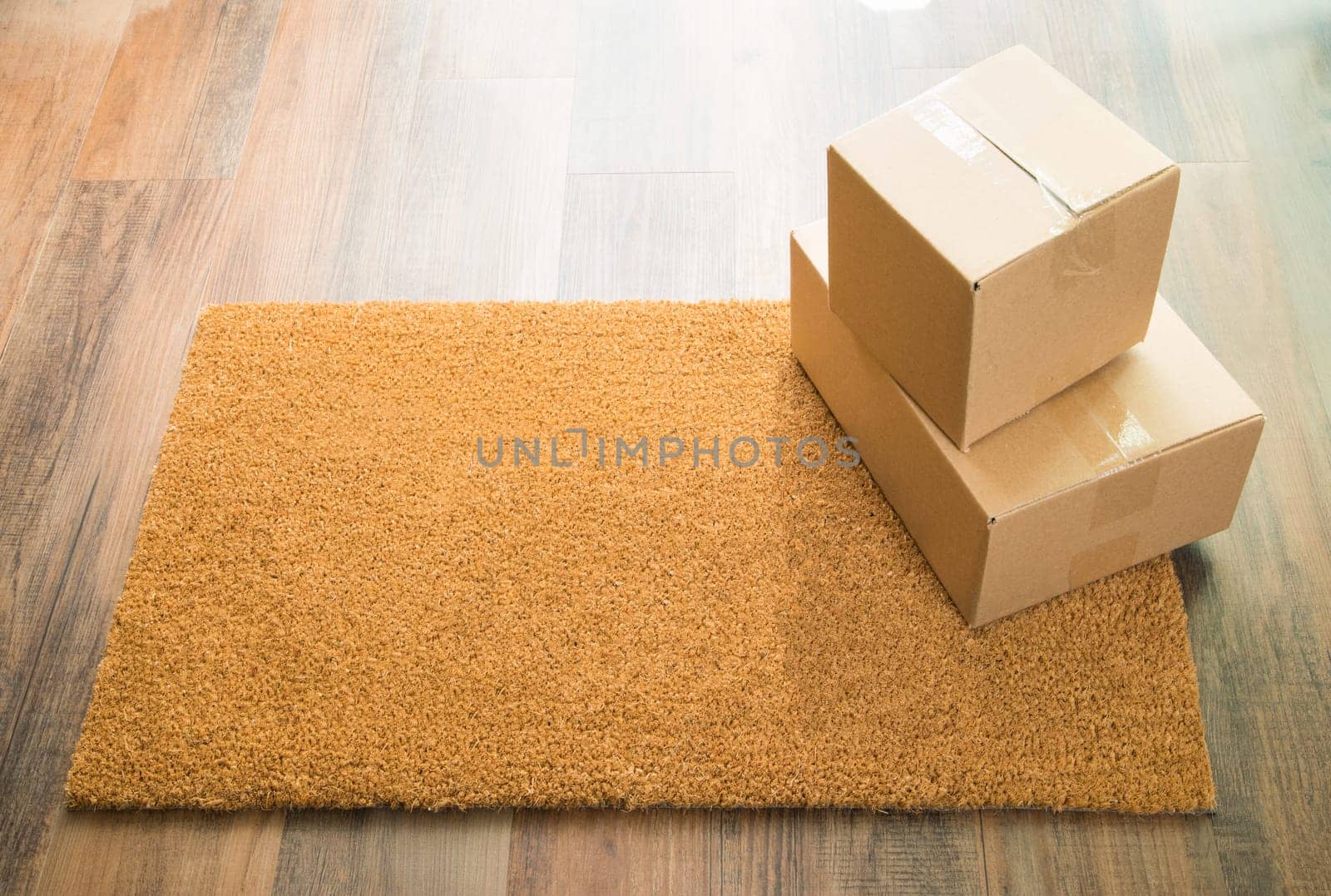 Blank Welcome Mat On Wood Floor With Shipment of Boxes.